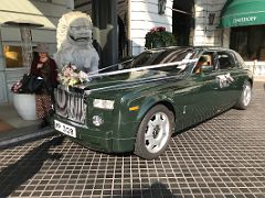 03C A green Rolls-Royce decorated for a wedding next to a guardian lion statue outside the entrance to The Peninsula Hotel Hong Kong